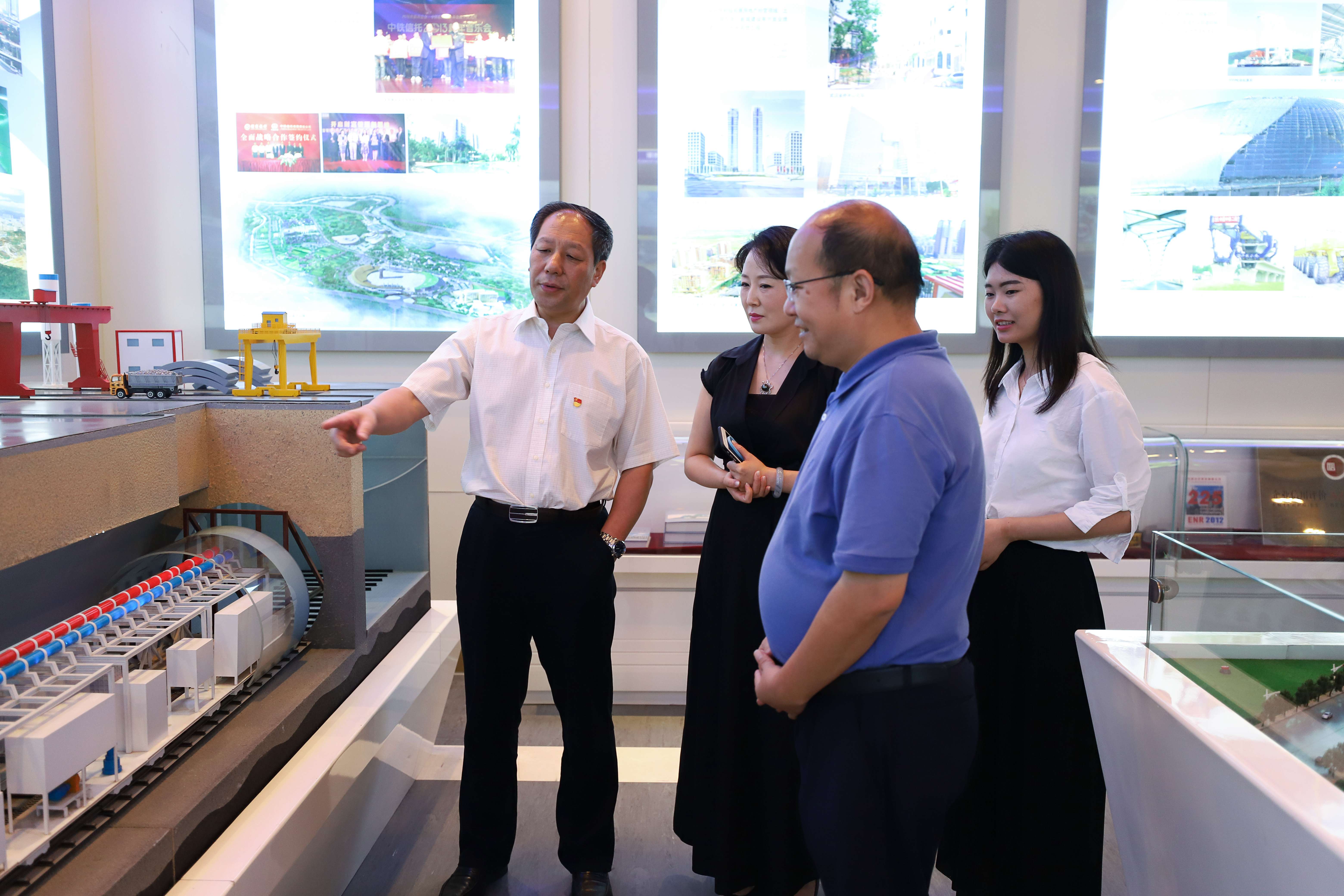 中國(guó)中鐵董秘何文（左一）向《證券日?qǐng)?bào)》記者介紹中鐵盾構(gòu)模型。（圖片來(lái)源：證券日?qǐng)?bào)）.jpg